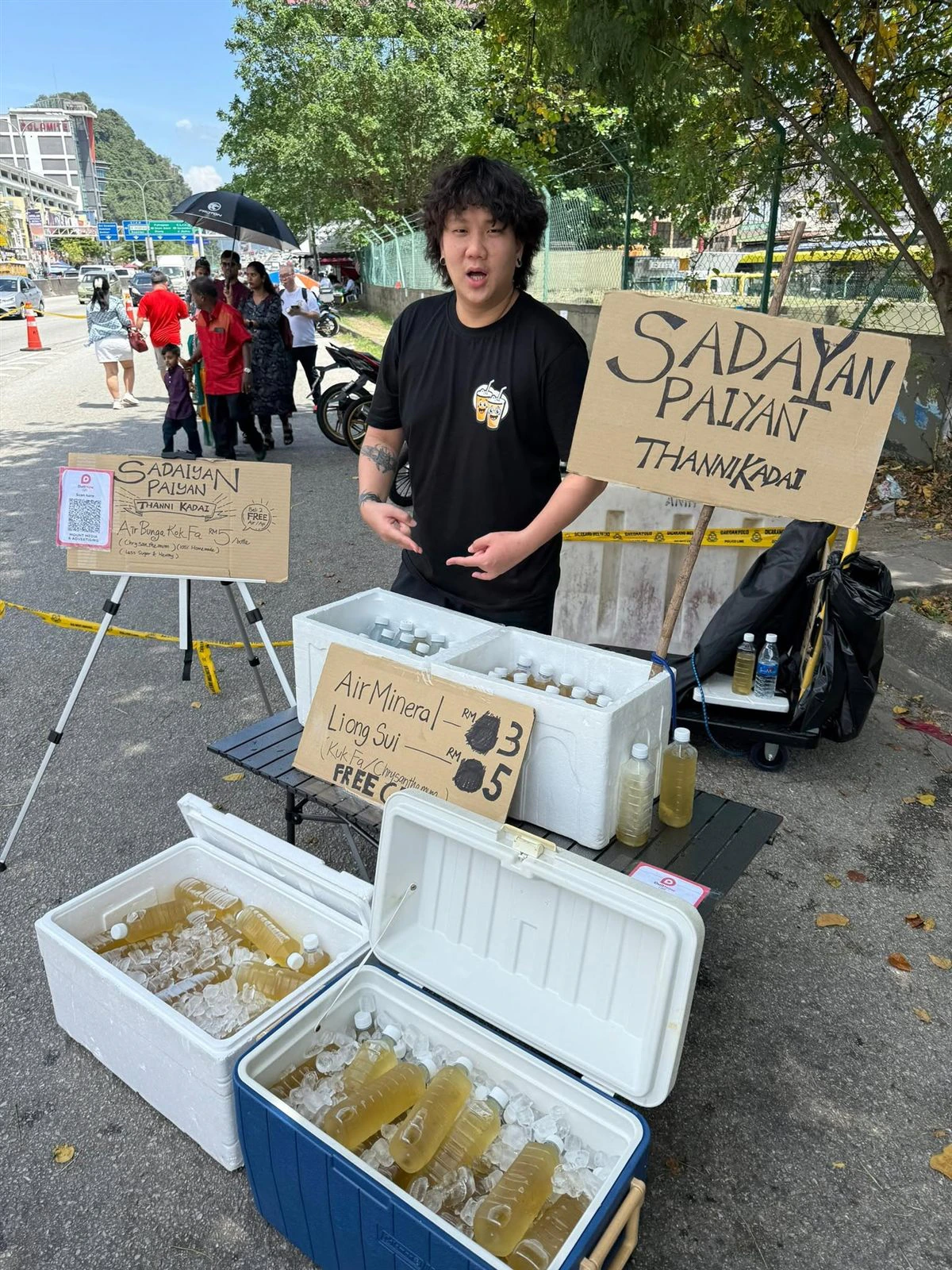 Kelvin at the Sadaiyan Paiyan Thanni Kadai with coolers of chrysanthemum drink