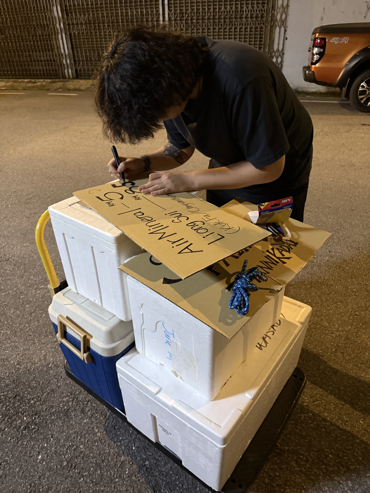 Kelvin hand-painting signs on the trolley and coolers before Sadaiyan Paiyan opened